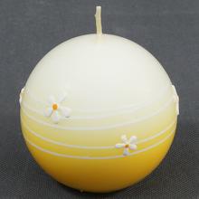Žltá guľa sviečky s kvetinovým vzorom.