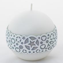 Biela vianočná sviečka s ornamentom.