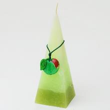 Ovocná sviečka v tvare pyramídy s jablkom.