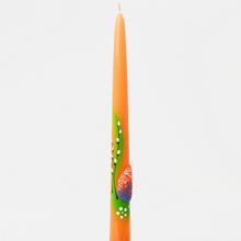 Veľkonočná sviečka v tvare špice, oranžová farba s dekoráciou.