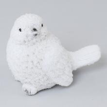 Biely keramický vtáčik s jemným povrchom.