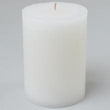 Biela vianočná sviečka v sklenenom obale.