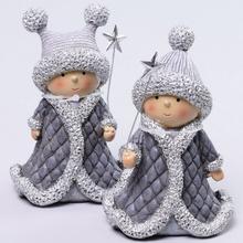 Dve deti v šedých kostýmoch s paličkami a čiapkami.