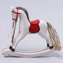 Drevený koň na hojdanie s červeným sedlom.