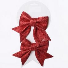 Červené trblietavé mašle na vianočné dekorácie.