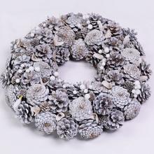 Biely šiškový veniec s dekoráciami na Vianoce.