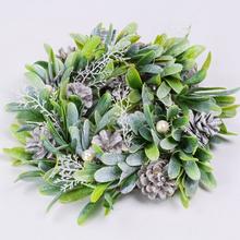 Vianočný veniec so šiškami a zelenými listami.