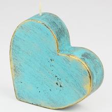 Srdcová sviečka v zelenej farbe s rustikálnym vzhľadom.