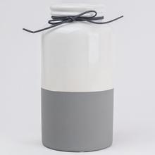 Biela a sivá váza s motúzkom.