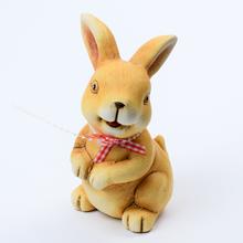 Keramický zajačik s červenou mašľou.