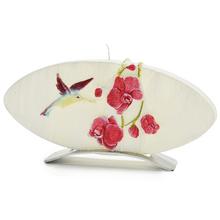 Sviečka s motívom orchideí a kolibríka v oválnom tvare.