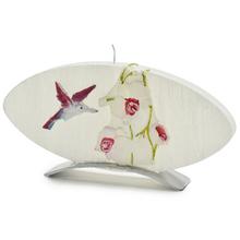 Ružová oválna sviečka s kvetinovým motívom a kolibríkom.