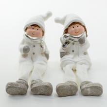 Dve snehové postavičky sediace v zimných oblekoch.