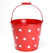 Veľké červené vedro s bielymi bodkami.