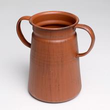Váza z kovu v bronzovej farbe s rozmermi 16,5x10,5x15,5 cm.