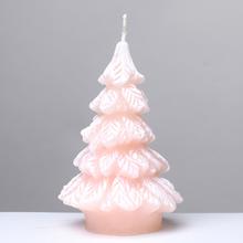 Ružová vianočná sviečka vo forme stromčeka.