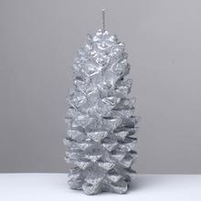 Strieborná sviečka v tvare šišky.