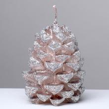 Ružovo-zlatá sviečka v tvare šišky.