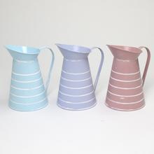 Malý kovový džbán s pruhmi v troch farbách.