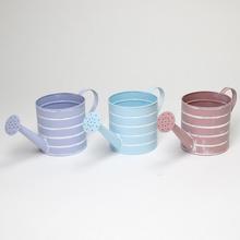 Malá kovová váza v mixe farieb s pruhmi.