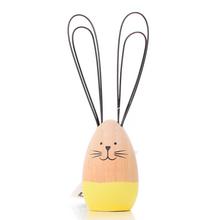 Drevený zajačik so žltými ušami a čiernymi drôtovými ušami.