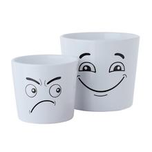 Dva keramické kvetináče s rôznymi výrazmi tváre.