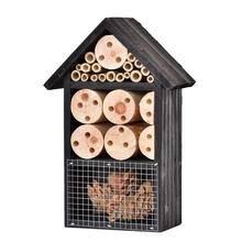 Domček pre hmyz s rôznymi otvormi a drevenými trubicami.