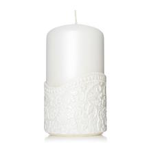 Biela sviečka s dekoratívnym vzorom.