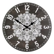 Nástenné hodiny s čiernym pozadím a bielym vzorom.