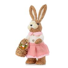 Slamená dekorácia zajac v ružových šatách s košíkom.