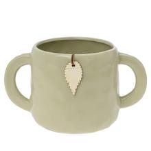 Zelený keramický obal s ušami.