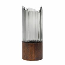 Váza z číreho skla s dreveným podstavcom.