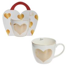 Šálka s zlatým srdcom a darčekovým obalom.