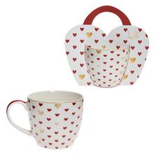 Šálka s červenými srdiečkami a zlatými detailmi.