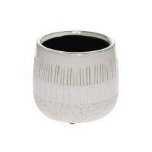 Biely keramický obal s textúrou.