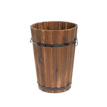 Drevený obal v tvare valca s kovovými pásmi.