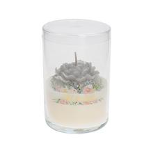 Veľká biela sviečka v skle s kvetinovým dizajnom.