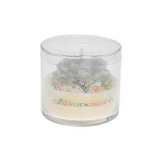 Malá biela sviečka v skle s kvetinovým dizajnom.