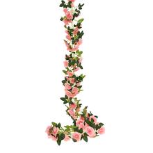 Umelá girlanda s ružovými kvetmi a zelenými listami.