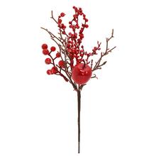 Umelý konárik s červenými jablkami a šípkami.