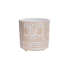 Biely a zlatý kvetináč na nohe s geometrickým vzorom.