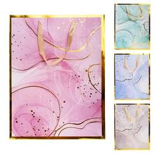 Darčeková taška M s rôznymi vzormi v pastelových farbách.