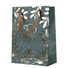 Vianočná papierová taška s motívom listov a nápisom 'Merry Christmas'.