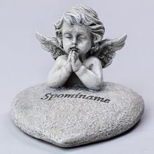 Smutný anjel s modliacimi rukami na srdci.