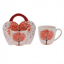 Šálka s motívom stromu a červenými listami.