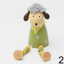 Drevená ovečka sediaca s farebnými guličkami.