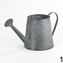 Kovová váza v tvare krhly s dekoratívnymi detailmi.