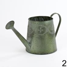 Kovová váza v tvare krhly s dekoratívnymi detailmi.