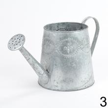 Kovová váza v tvare krhly s dekoratívnymi detailmi.