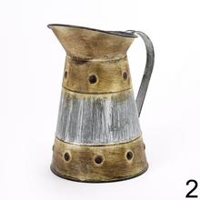 Malý kovový džbán s dekoratívnym dizajnom.